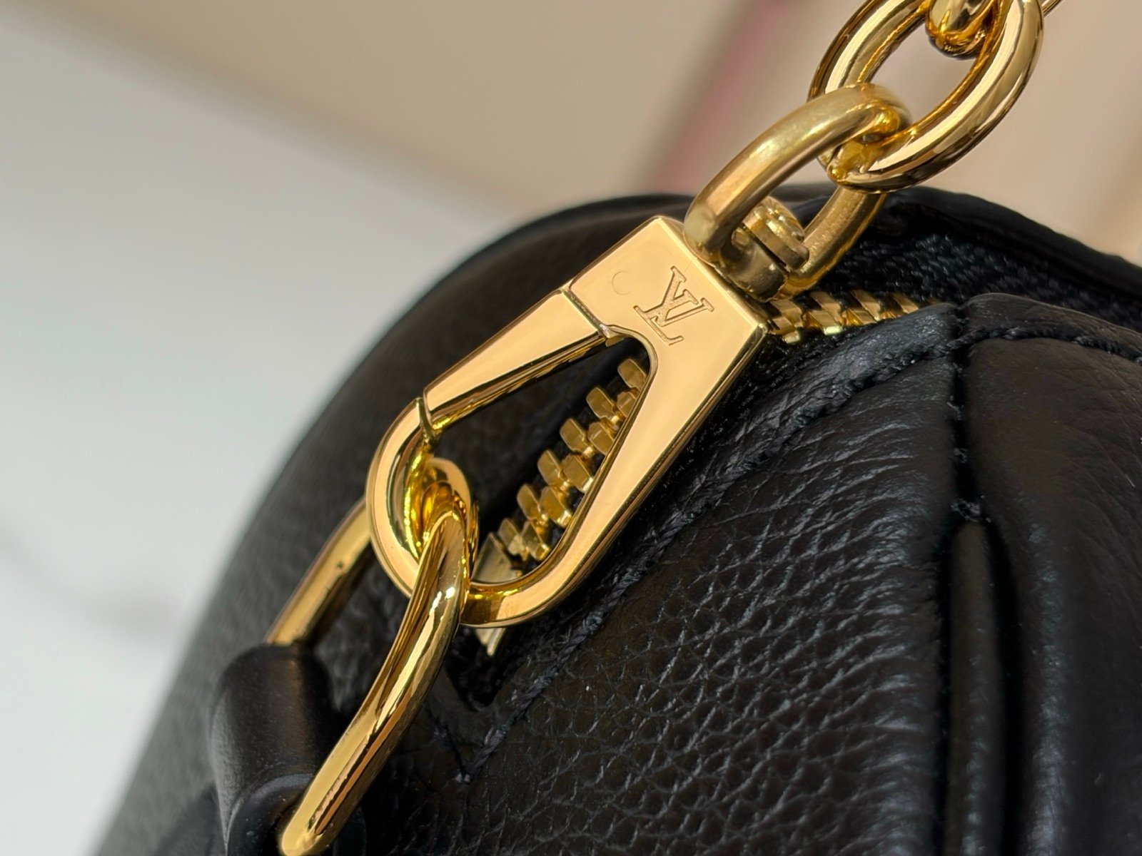 Black Embossed Compact Boston Bag strap detail view with embossed texture and silver tone hardware