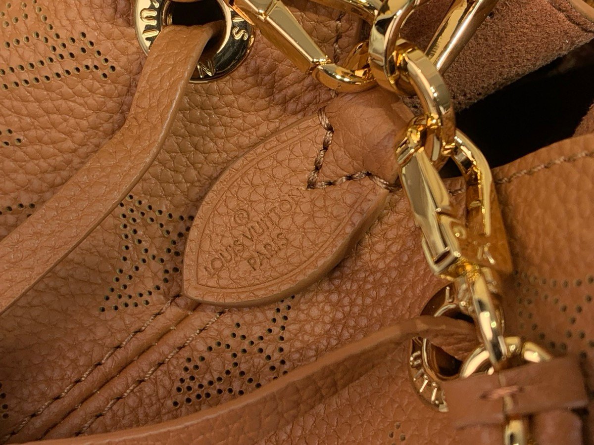 Brown Perforated Mini Bucket Bag strap detail view with perforated leather texture and braided handle