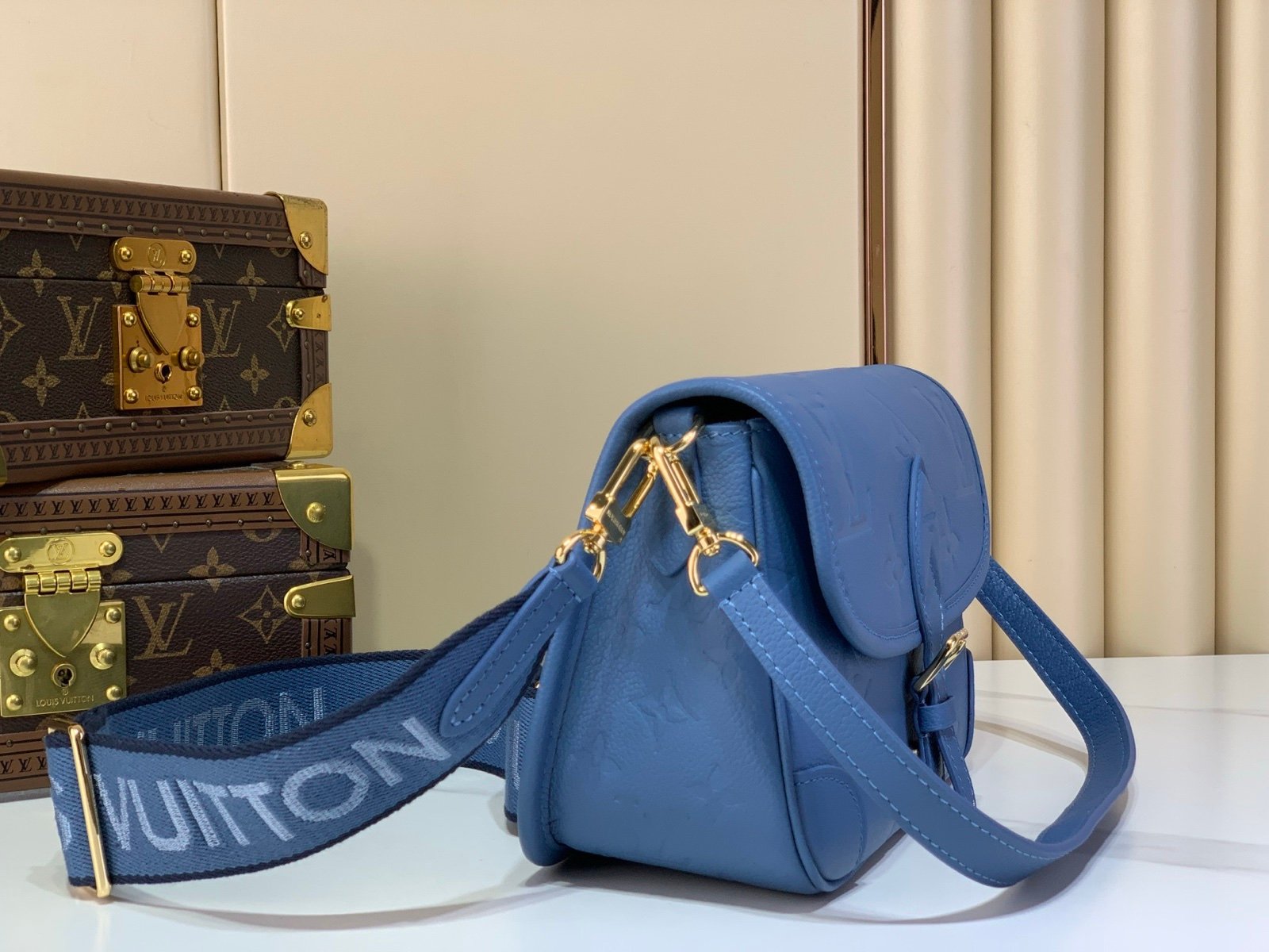 Mist Blue Embossed Baguette Bag angle view with embossed grained texture with a wide woven strap