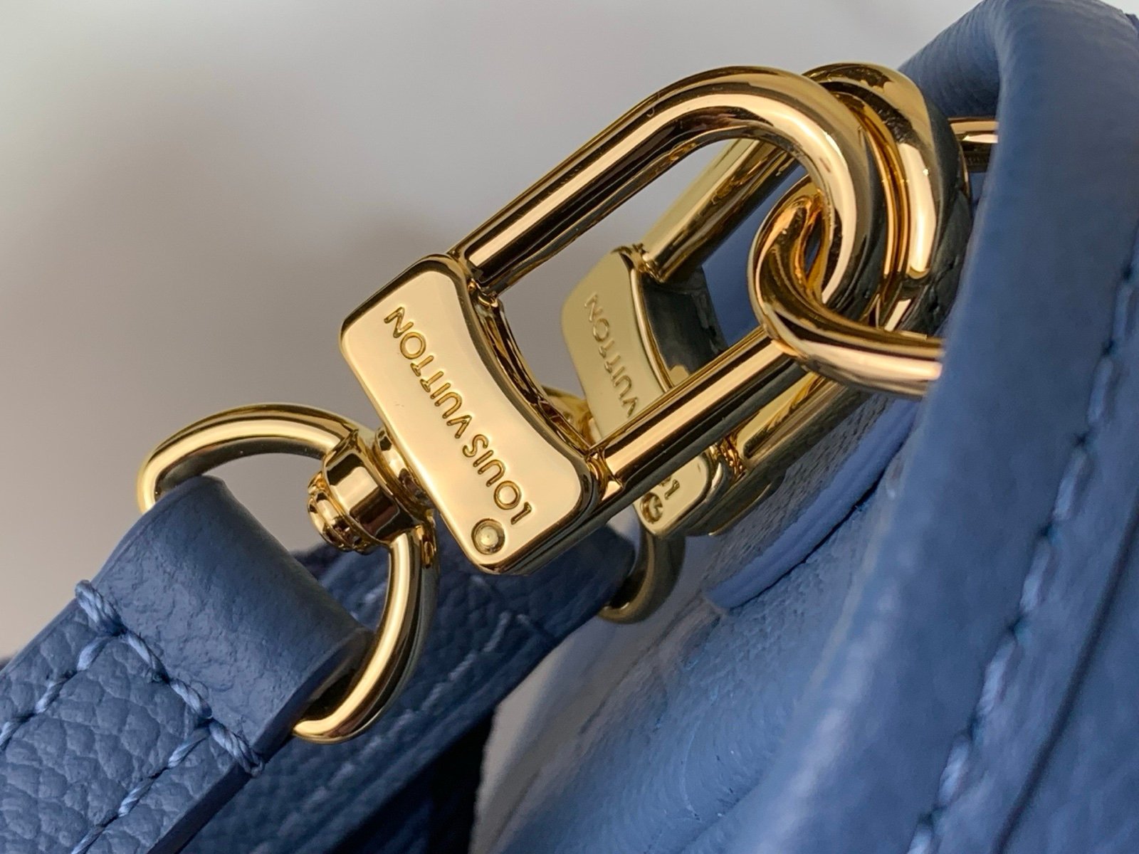 Mist Blue Embossed Baguette Bag hardware detail view with embossed grained texture with a wide woven strap
