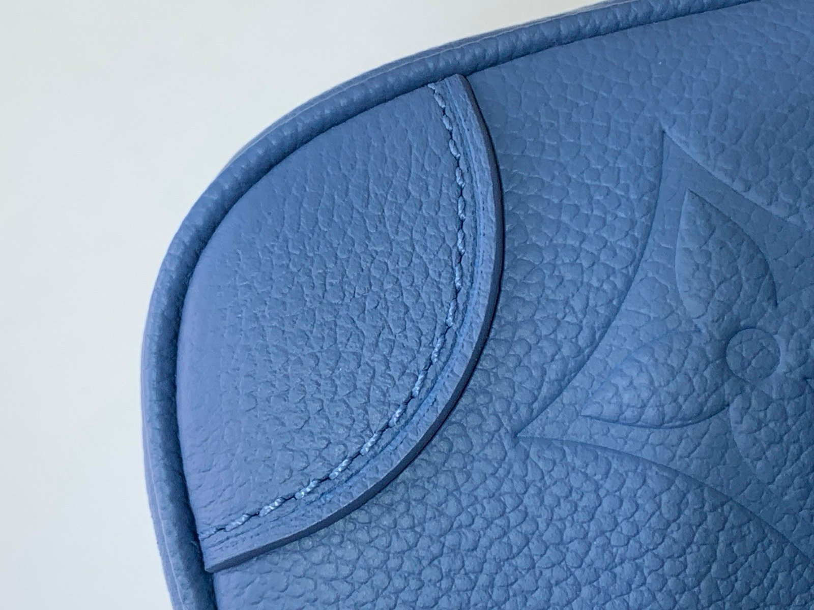 Mist Blue Embossed Baguette Bag strap detail view with embossed grained texture with a wide woven strap