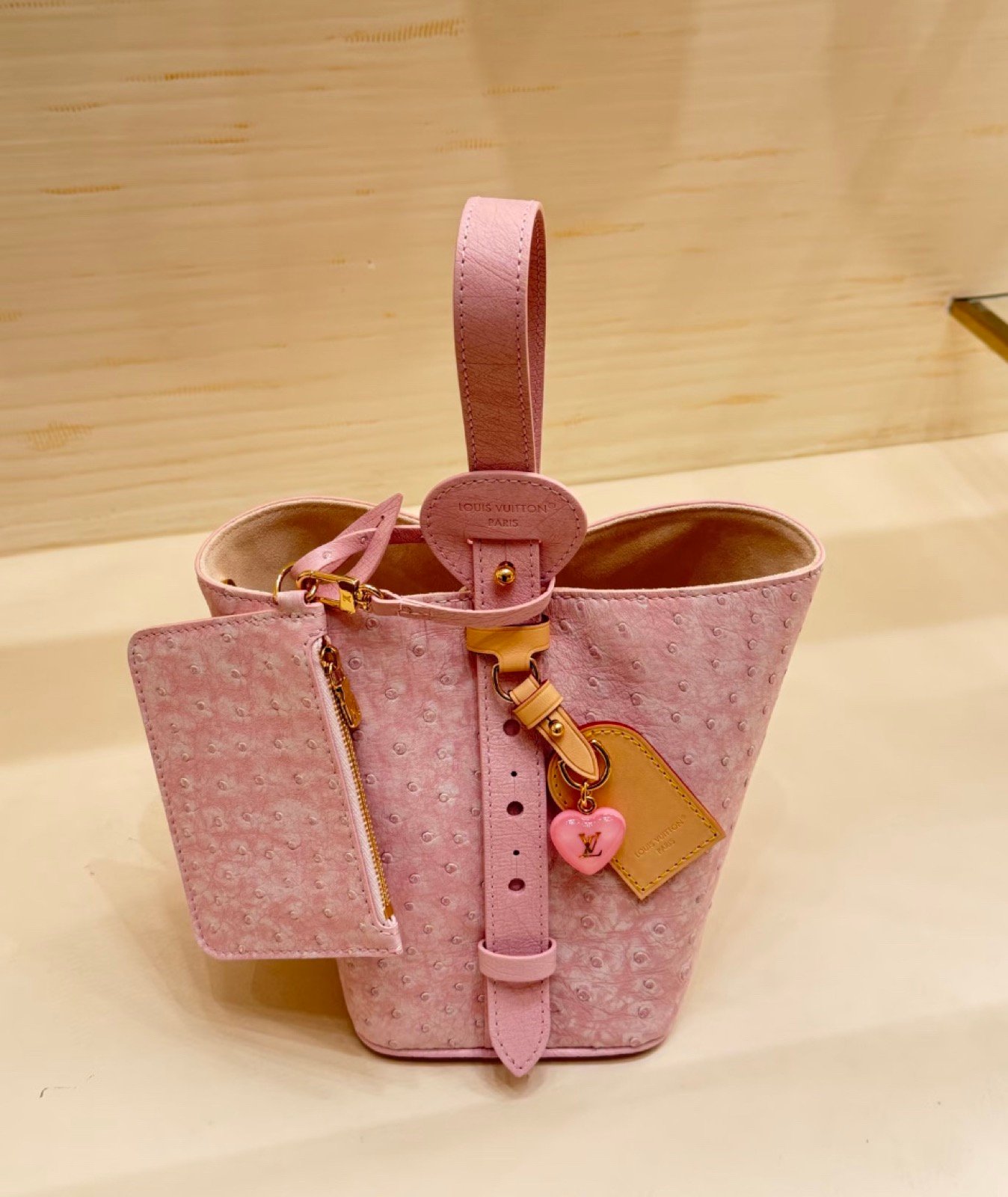 Pink Ostrich Texture Bucket Bag side view with ostrich texture and smooth trim
