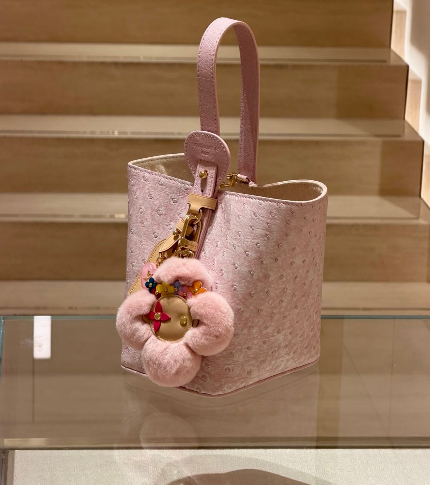 Pink Ostrich Texture Bucket Bag strap detail view with ostrich texture and smooth trim